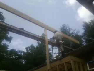 Carpenter setting a ridge beam over a new addition frame — Ice Dam Removal by Roofing Brothers in Rancocas