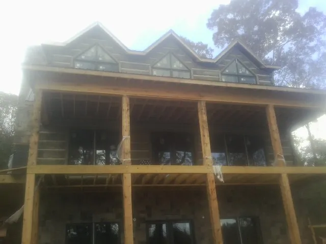 Dormers and porch framing on a large log home under construction — Roof Coating work by our crew in Rancocas