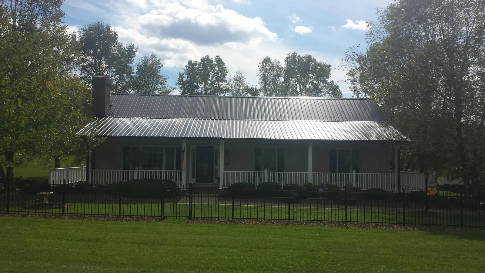 Gray metal roof on a brick ranch with a full width front porch — Gutter Guard Installation work by our crew in Rancocas