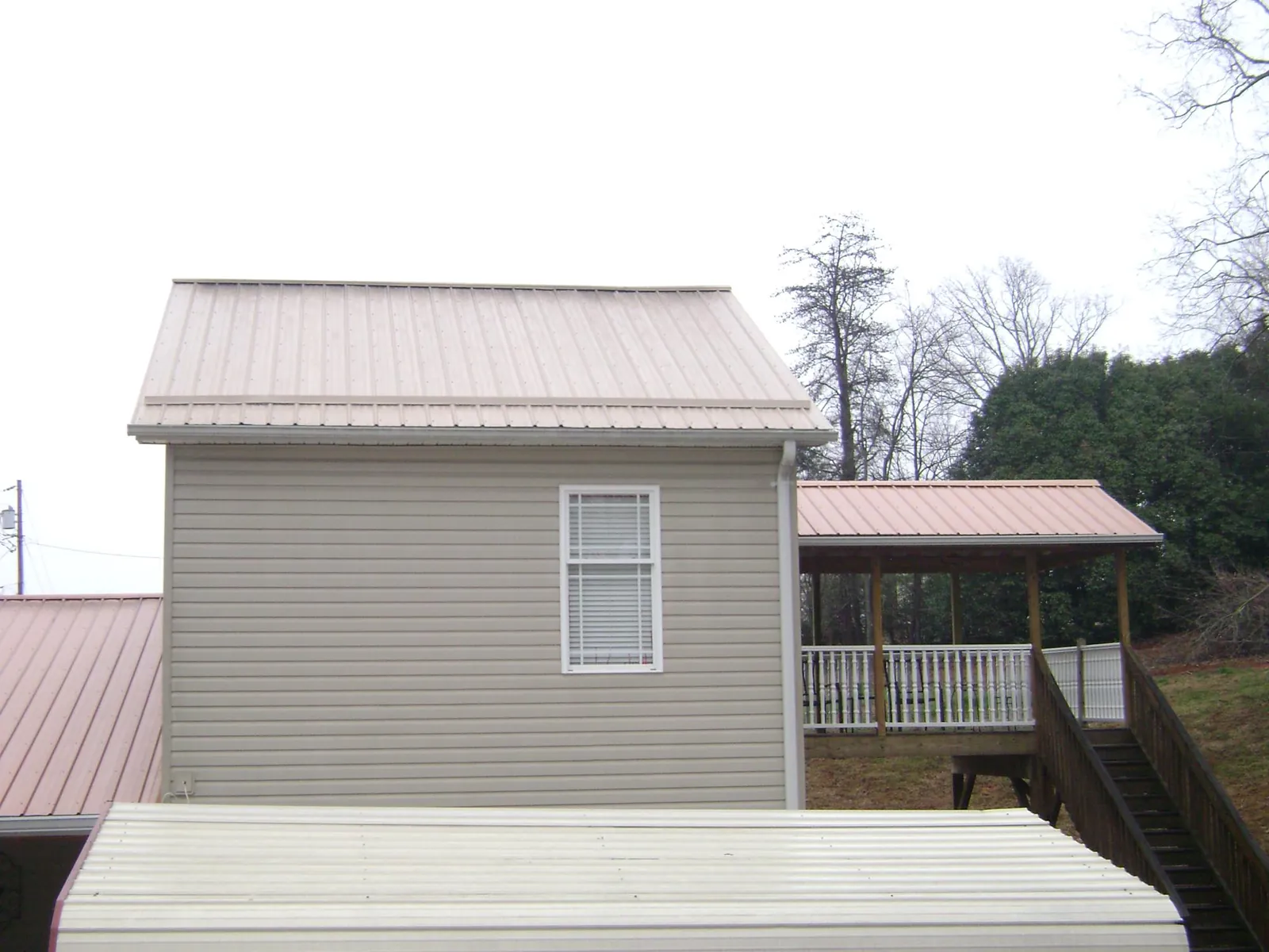 Tan metal roofs on a two story addition and attached porch, from a Roof Replacement job in Rancocas